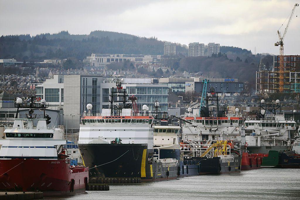 A line of boats and vessels with Aberdeen city in the background. 