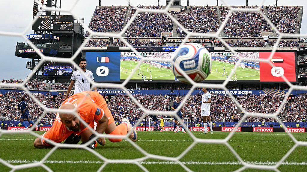 Iraq goalkeeper Ahmed Basil looks on as France forward Kylian Mbappe's shot hits the net in the World Cup group game in Philadelphia on 22 June, 2026