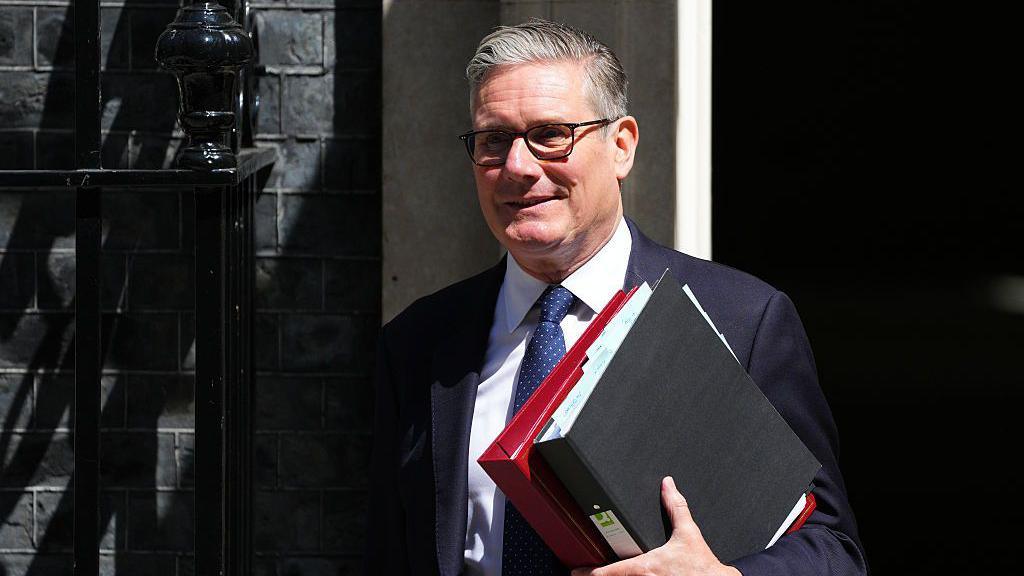 Keir Starmer carries folders out of No 10