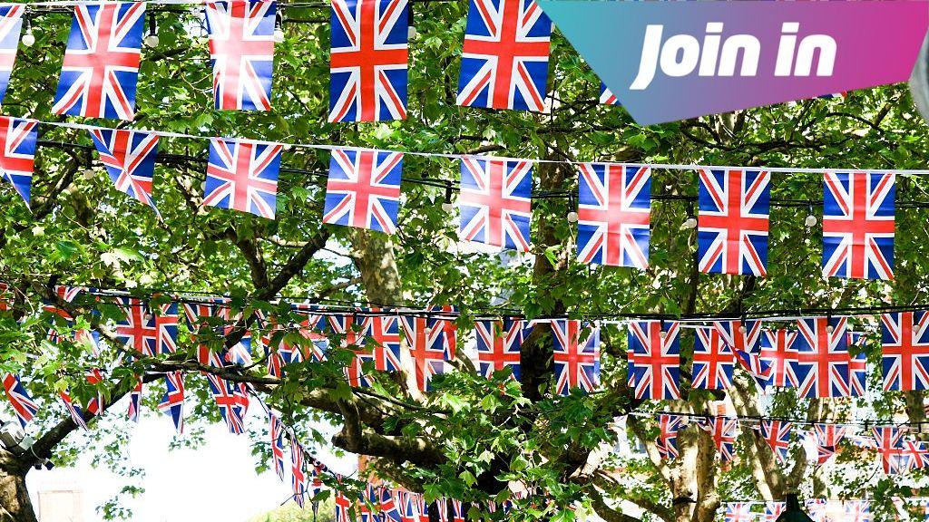 Bunting hanging up across trees outside.