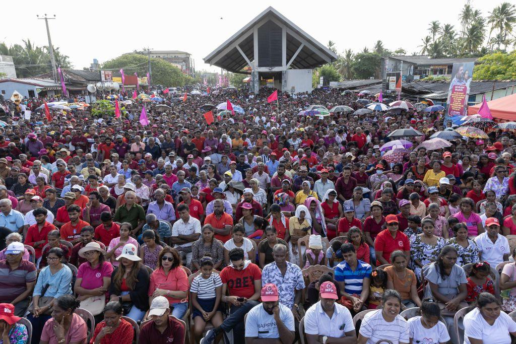 A large crowd of people sitting in an outdoor location