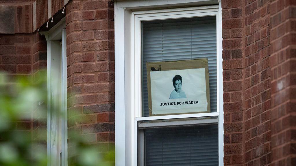 A photo in a window of a boy. It says 'Justice for Wadea"