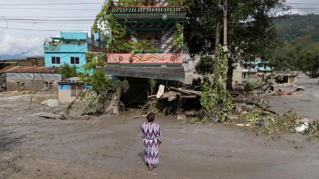 A flood survivor returns to home following a flash flood in Devighat Village, Nuwakot district, Nepal