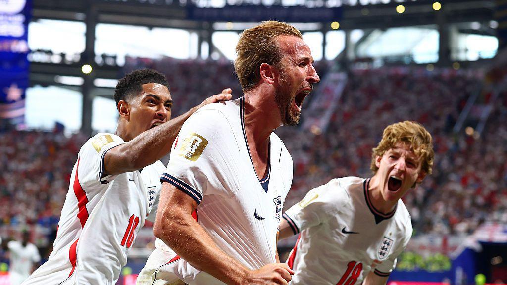 Jude Bellingham and Anthony Gordon celebrating Harry Kane's goal.