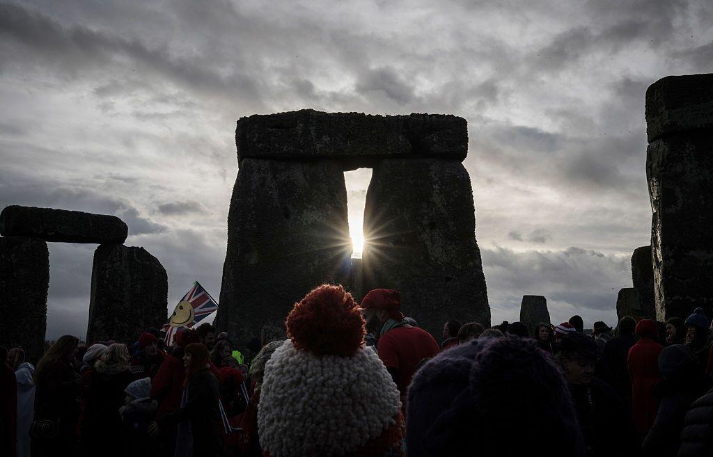 A crowd gathers as the Sun aligns with the rocks at Stonehenge.