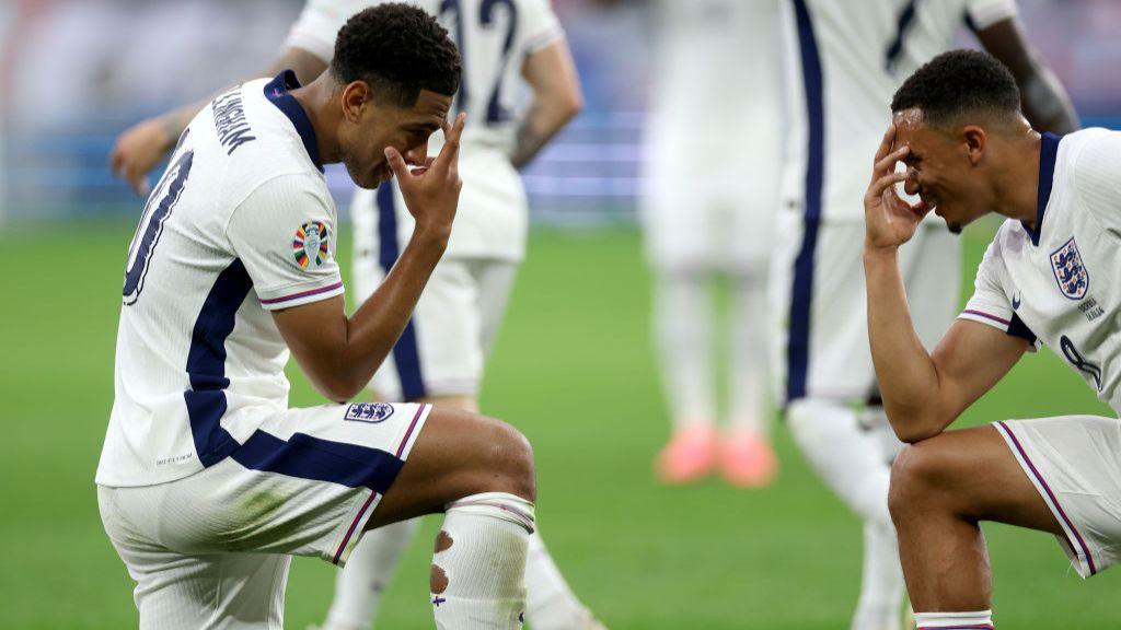 Jude Bellingham and Trent Alexander-Arnold celebrate by kneeling down and covering their face 