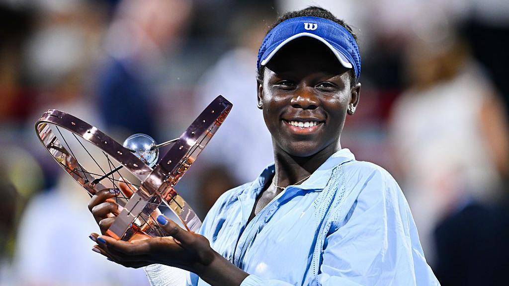 Victoria Mboko smiles as she holds the Canadian Open trophy