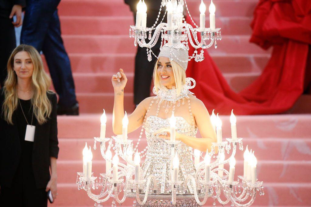 Katy Perry (blonde) wearing a silver chandelier dress that's lit up