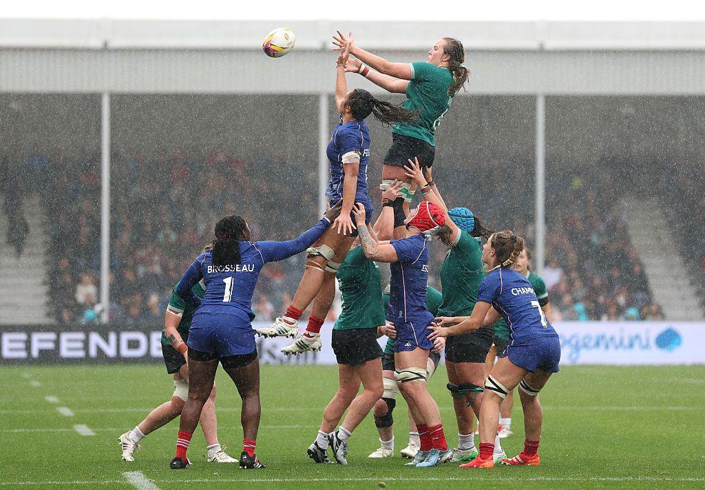 Fiona Tuite of Ireland and Manae Feleu of France compete in a lineout. They are both being help up by their team mates as the ball comes towards them in the pouring rain