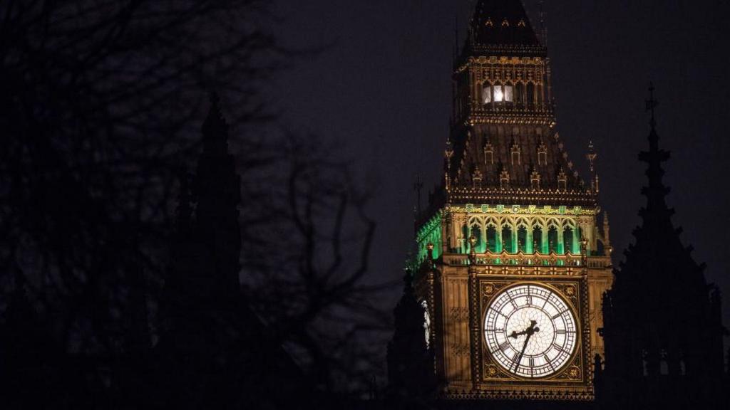 A shot of the clock face on the Elizabeth Tower taken at night. The Ayrton Light can be seen at the top of the tower