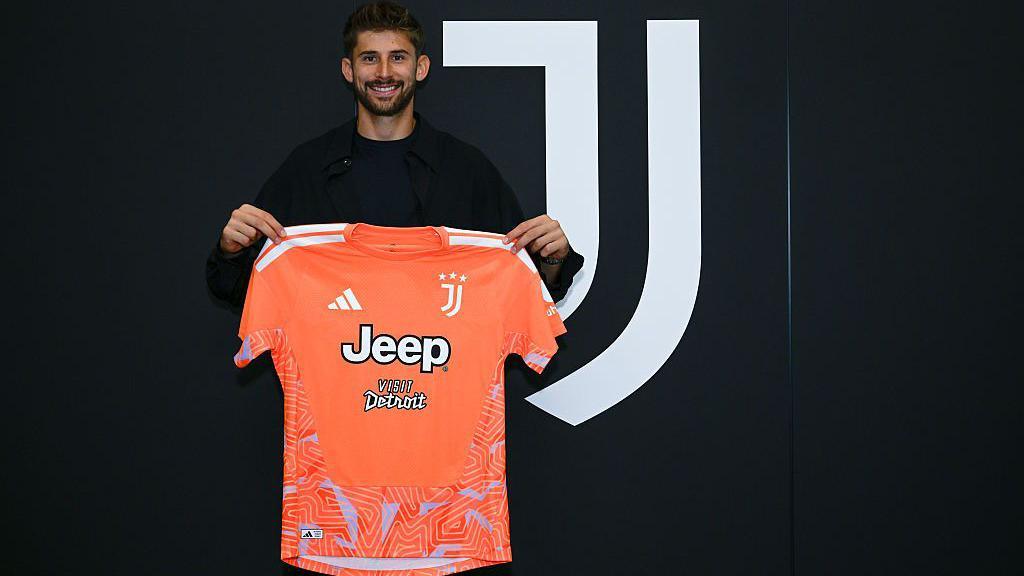 Guglielmo Vicario holding Juventus shirt
