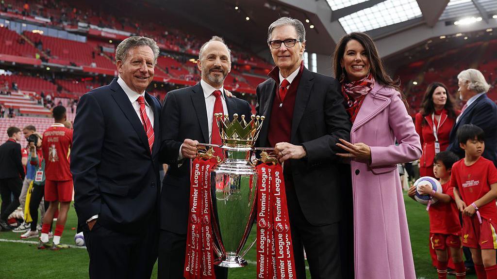 Tom Werner, Chairman of Liverpool, Michael Gordon, President of Fenway Sports Group and John Henry, Principle Owner of Liverpool and his wife Linda Pizzuti Henry pose for a photograph with the Premier League trophy.