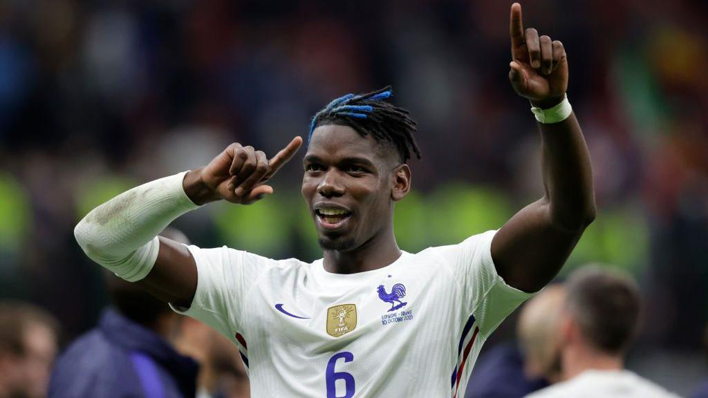 Paul Pogba holds his arms up in the air