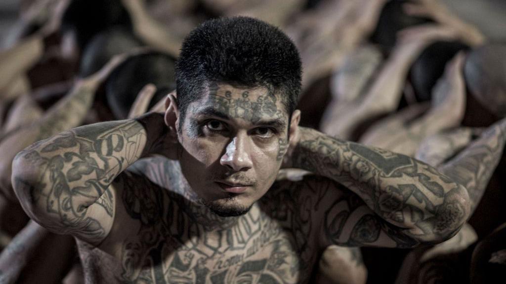 A tattooed inmate looks into the camera in this photo handed out by the Salvadorean presidency.