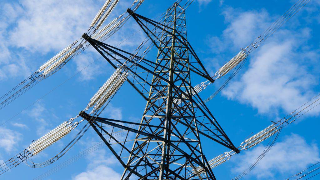 An electricity pylon against a blue sky