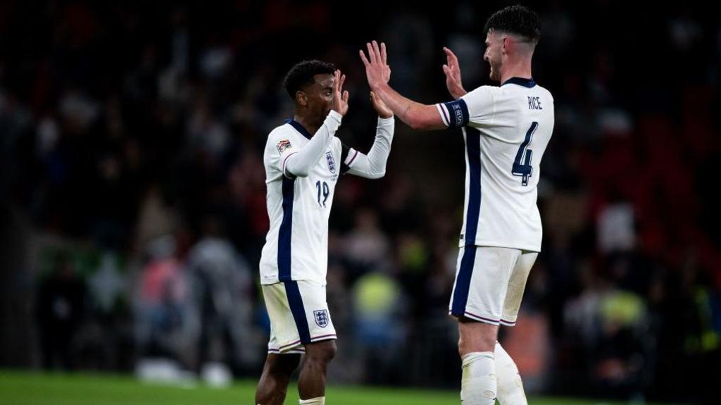 Angel Gomes and Declan Rice high-five each other in England shirts