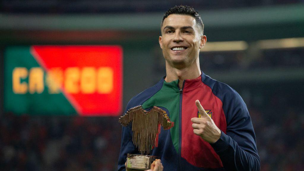 Cristiano Ronaldo holds an award ahead of making his 200th appearance for Portugal last year.