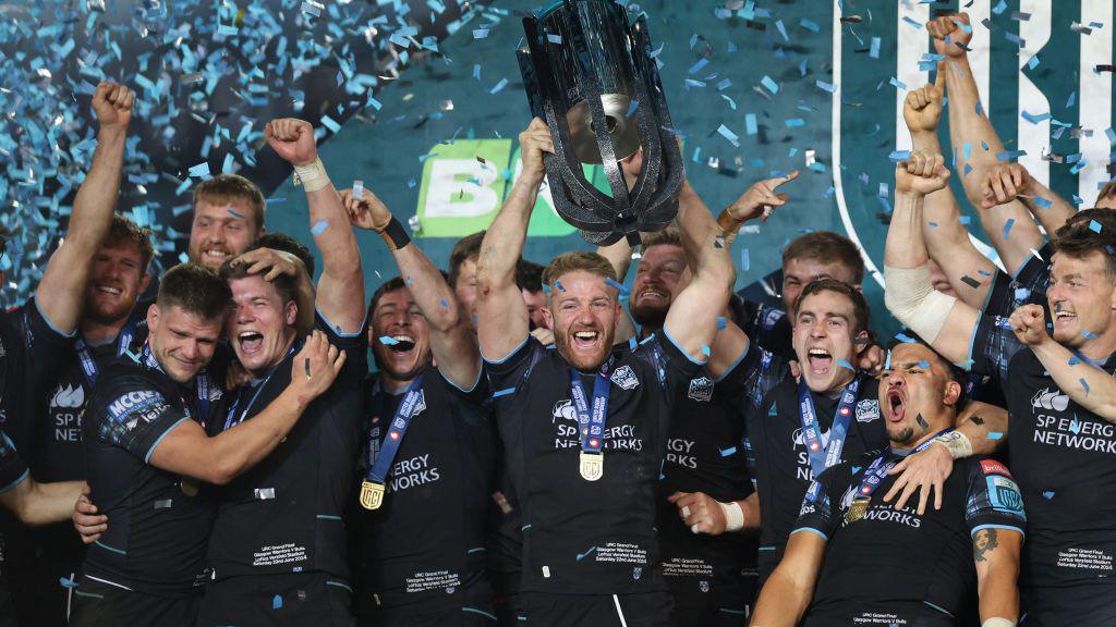 Glasgow Warriors players celebrate with the trophy after winning the United Rugby Championship (URC) final match between The Bulls (Pretoria) and Glasgow Warriors (Glasgow) at Loftus Versfeld stadium in Pretoria, on June 22, 2024