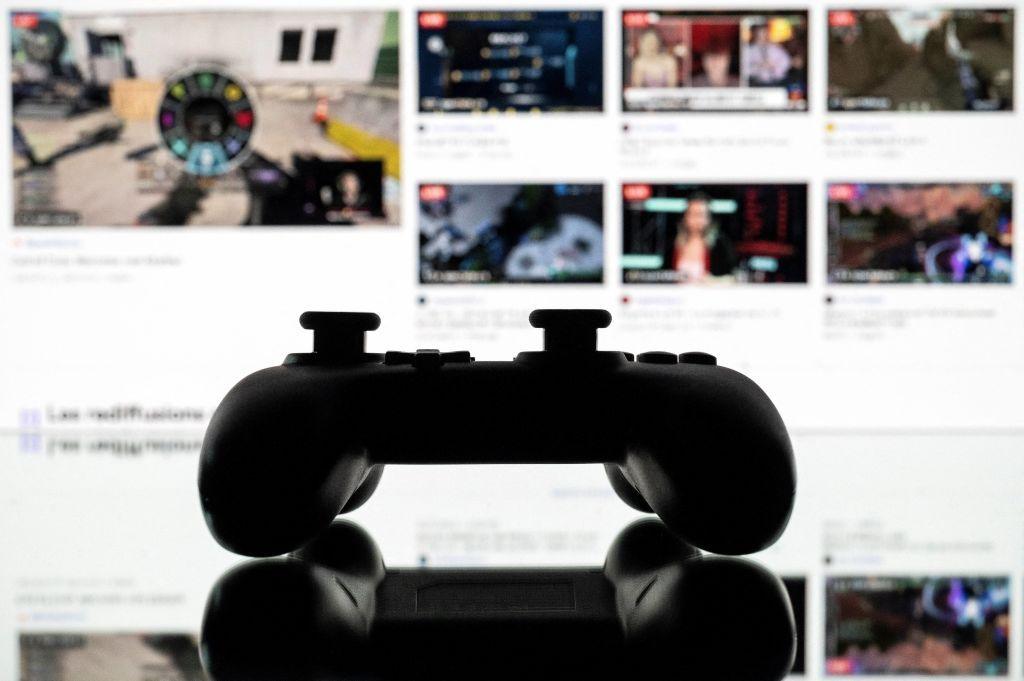 A games console controller backlit by a screen showing a Twitch profile