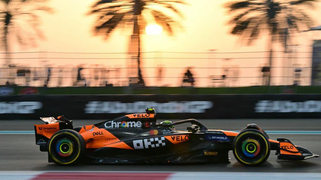 McLaren's Lando Norris in Abu Dhabi Grand Prix practice with the sun setting in the background