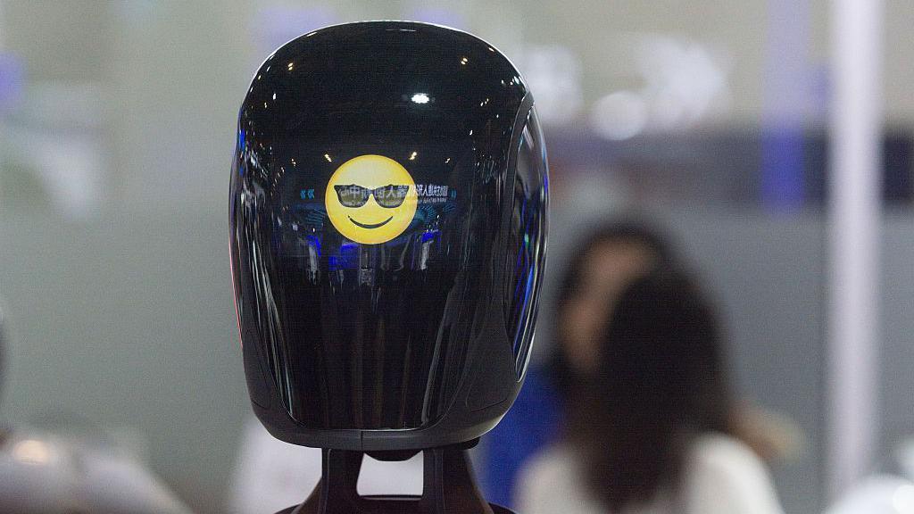 robot face with a sunglasses emoji on a black screen 