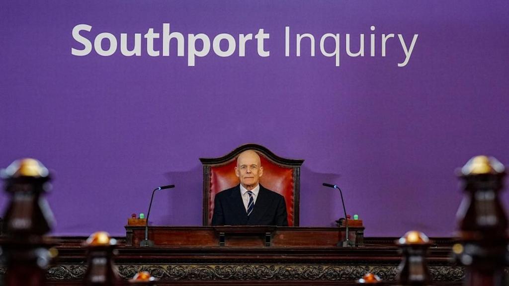 Sir Adrian Fulford sitting inside the hearing room at Liverpool Town Hall, Liverpool