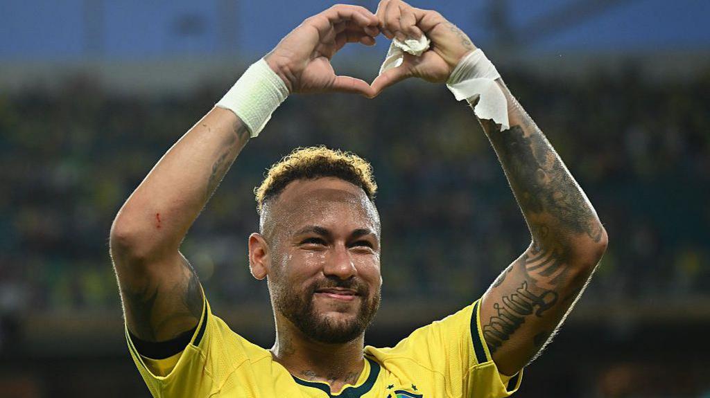 Neymar makes the heart sign with his hands while he celebrates Brazil's win over Scotland in Miami