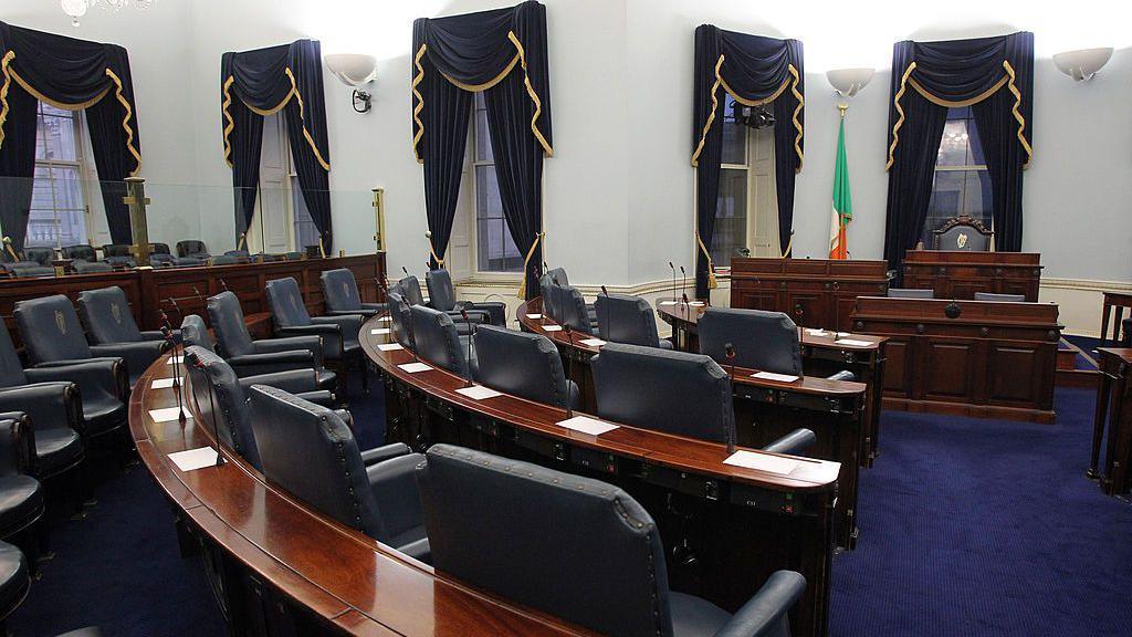 Ireland's Seanad chamber, also known as the upper house of the Irish parliament, is pictured in Leinster House in Dublin, Ireland, on October 2, 2013. Rows of seating can be seen facing towards desks with the Irish flag on the back wall.