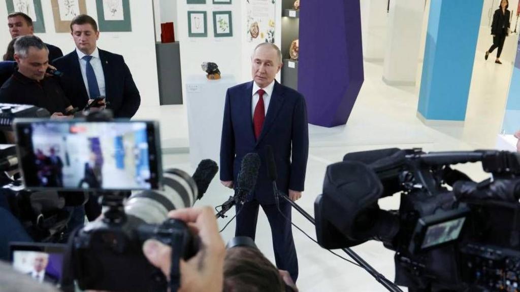 Putin poses with cameras