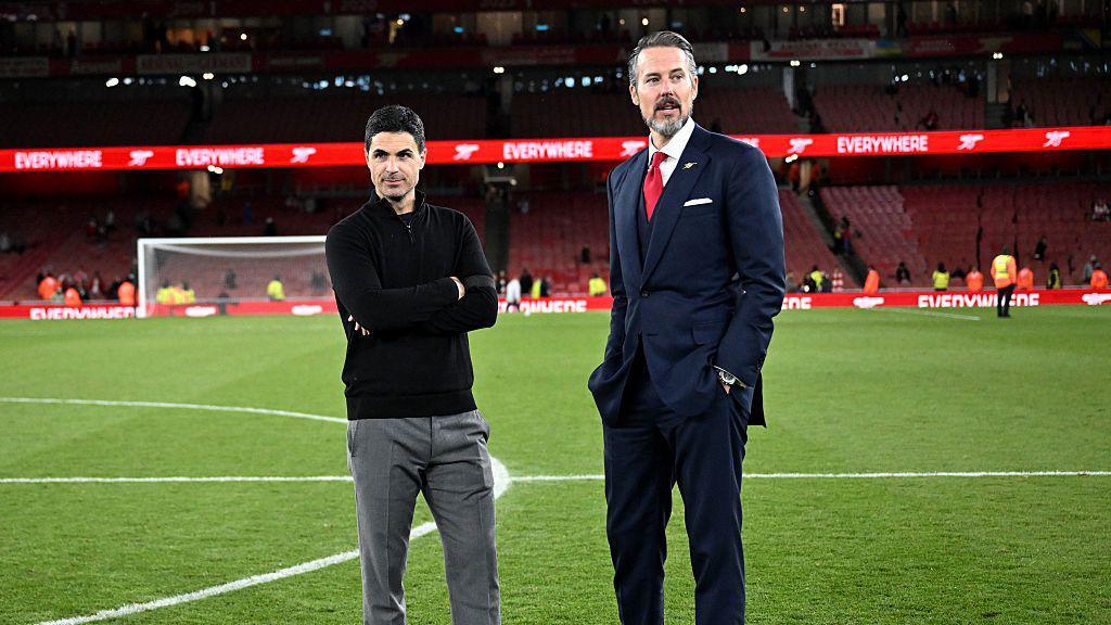 Mikel Arteta talks to Josh Kroenke on the Emirates Stadium pitch