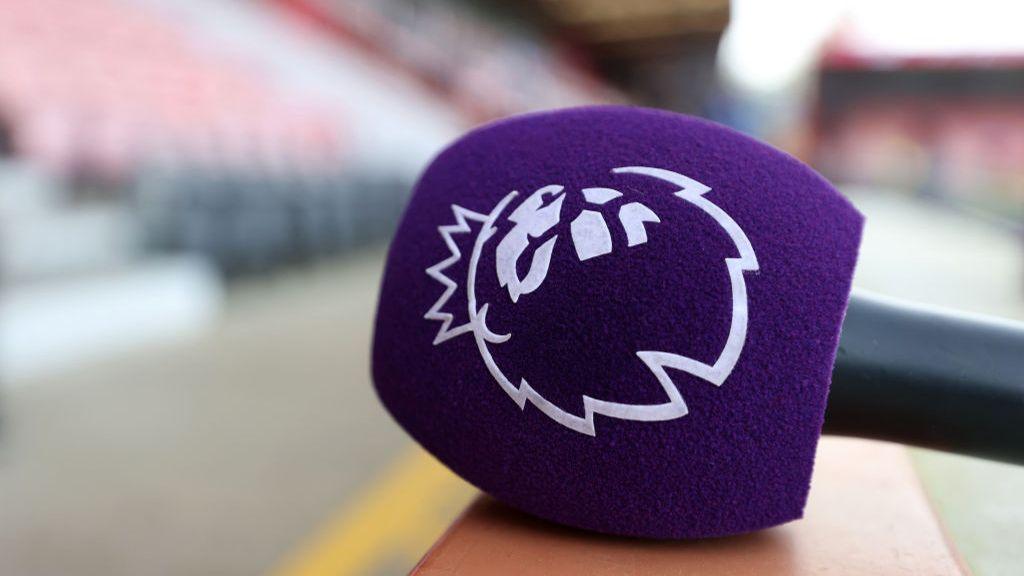 A close-up photo of a microphone with the Premier League logo