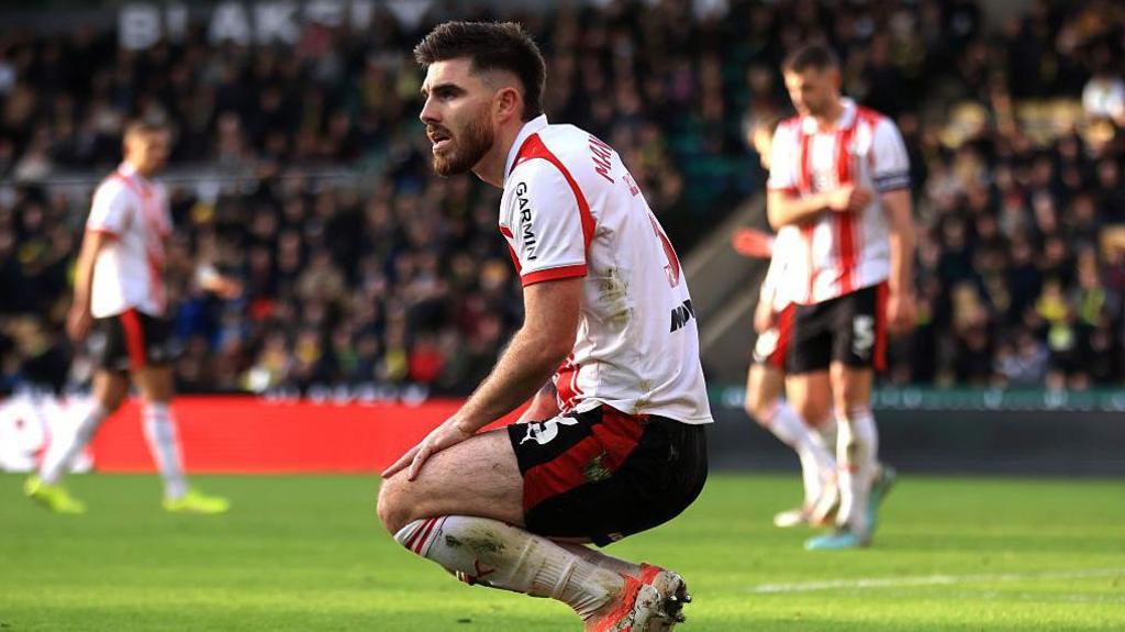 Ryan Manning squats down, disappointed, as Southampton fall to defeat at Norwich