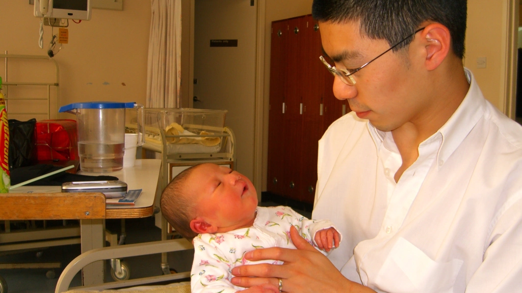 Caitlyn Scott-Lee as a baby being held by her father