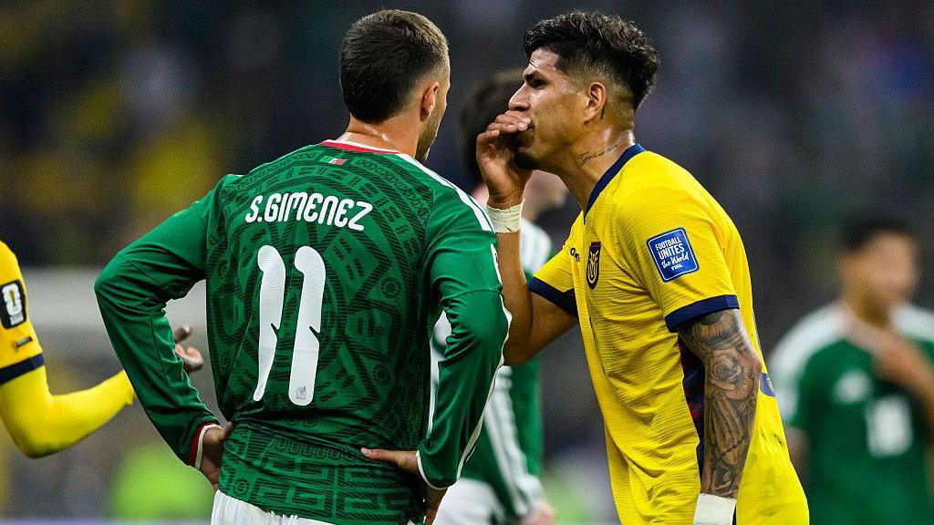 Piero Hincapie of Ecuador covers his mouth while arguing with Santiago Gimenez of Mexico