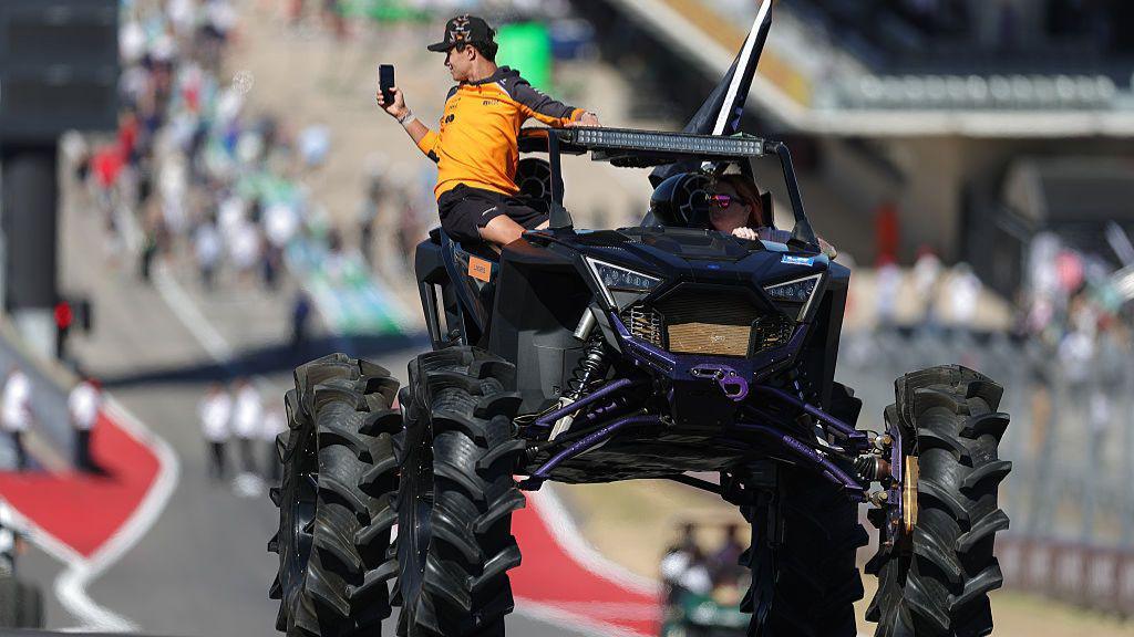 Norris rides atop a lifted off-road truck during the drivers’ parade