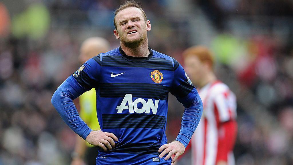 Wayne Rooney grimaces with his hands on his hips