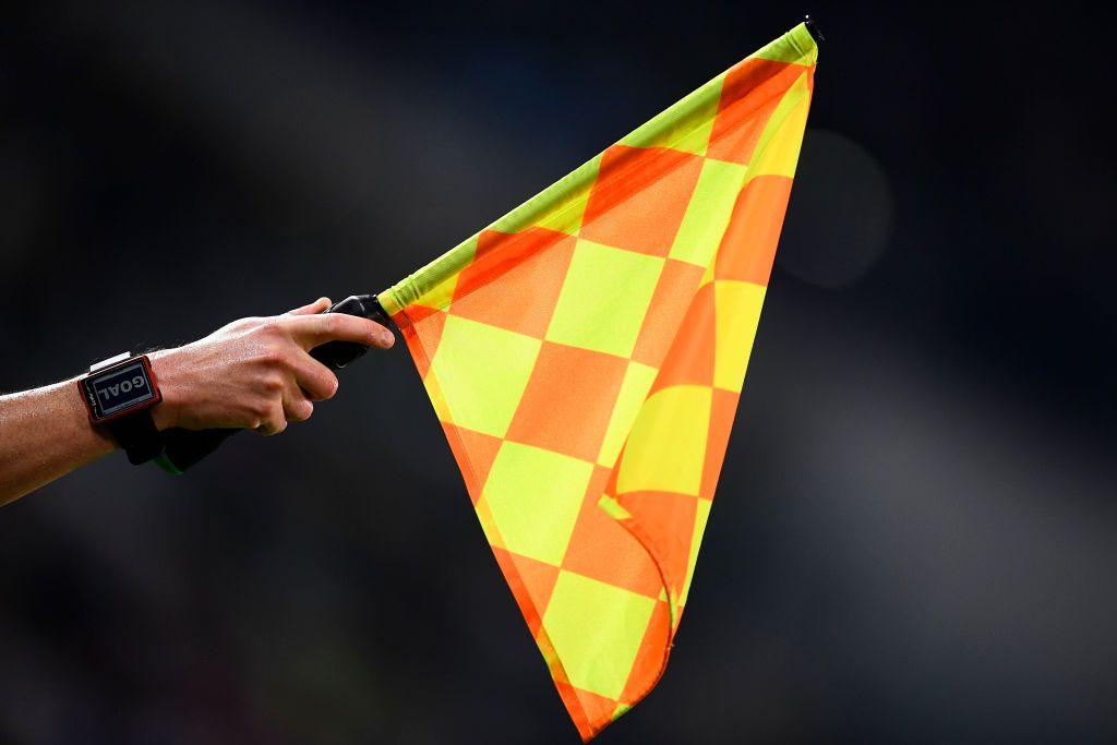 A linesman raises the offside flag during a football match