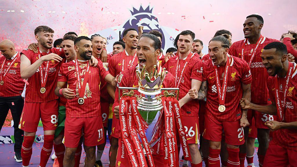 Virgil van Dijk prepares to lift the Premier League trophy as the squad celebrate