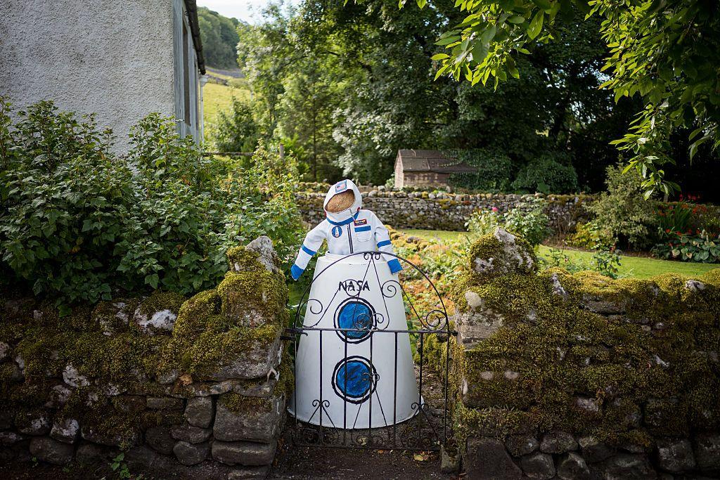 A scarecrow is dressed as an astronaut inside a model Nasa spacecraft.