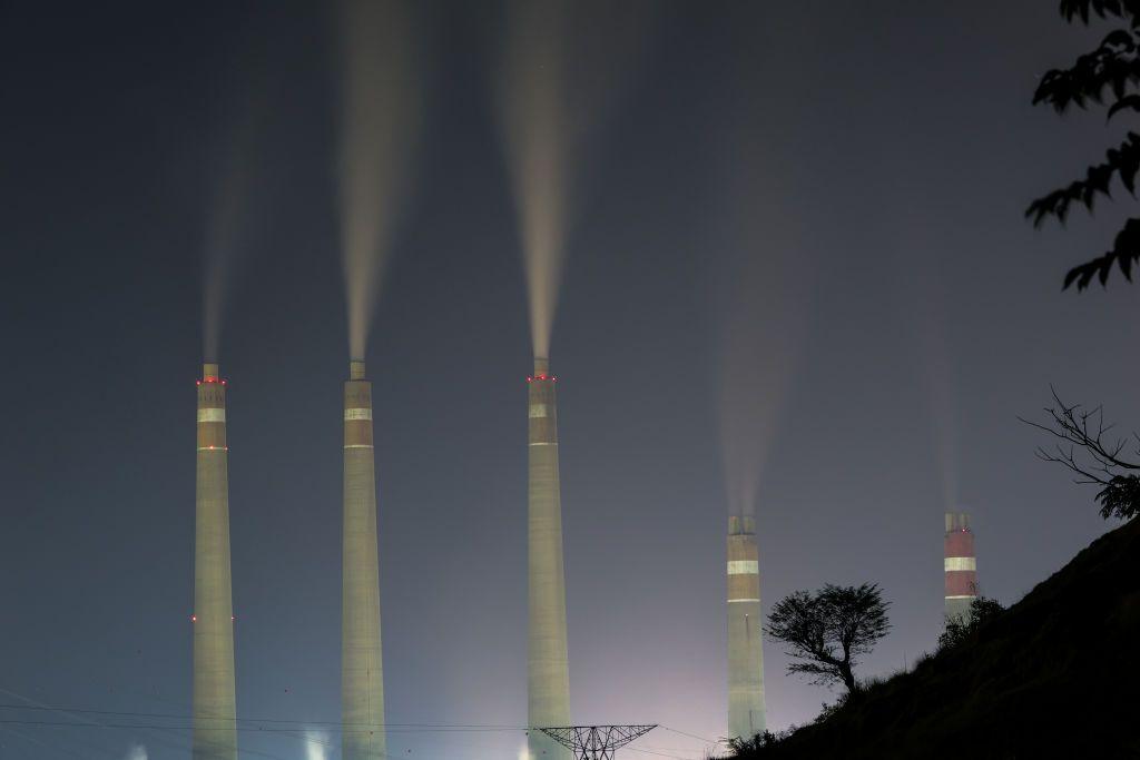 View of Suralaya coal power plant while smoke and steam billows seen from Suralaya village in Banten province, Indonesia