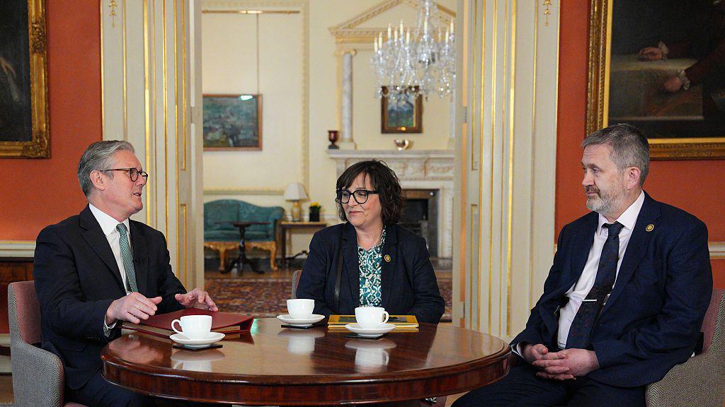 The parents of Martyn Hett meet Prime Minister Sir Keir Starmer earlier in 2025. Figen and Stuart Murray are sat at a wooden table in a grand Downing Street room with Starmer on the other side. They are shown in mid conversation.