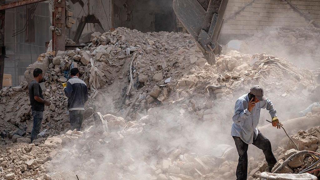 Iranian workers amid the debris of a building targeted in Israeli attacks in Tehran, Iran, on August 16, 2025. 