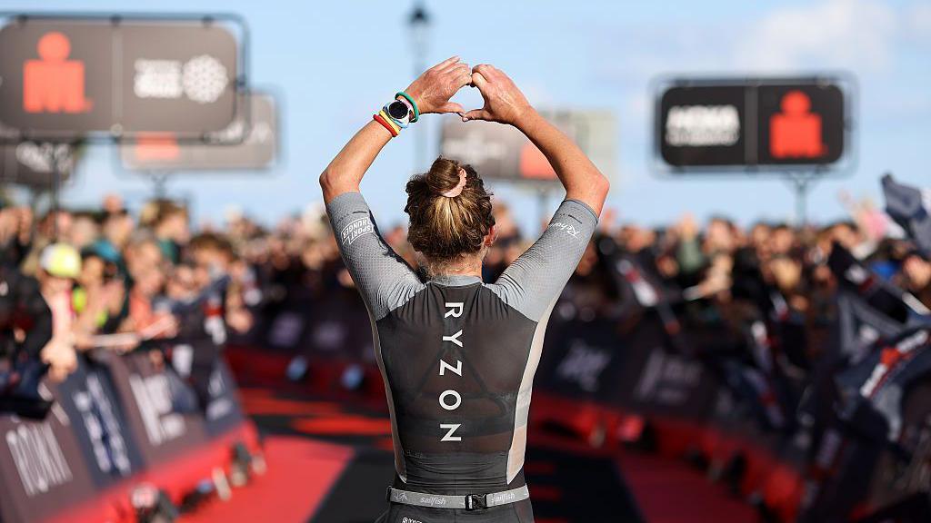 Franziska Hofmann salutes the crowd at the finish line