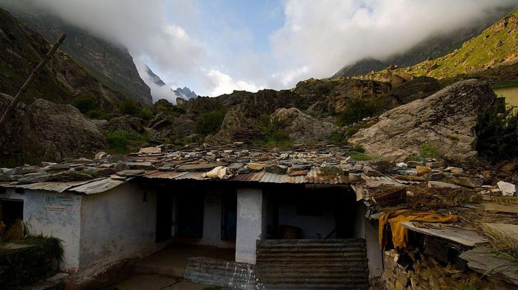 A small house at the village Mana which is the last civilian settlement just 24 km from the border between India and Tibet. This village is located at the foot of the Himalayas surrounded by the tall mountains and covered by clouds and lush greenery.