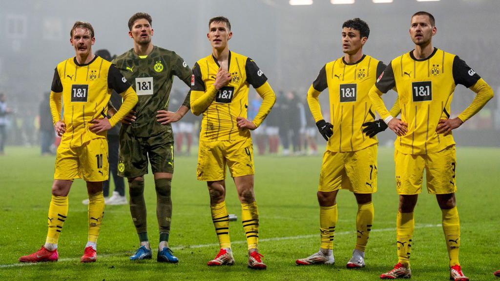 Borussia Dortmund players Julian Brandt, Gregor Kobel, Nico Schlotterbeck, Giovanni Reyna and Waldemar Anton look on after defeat against Holstein Kiel