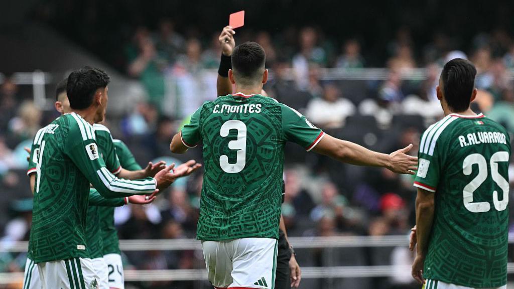 Cesar Montes is shown a red card