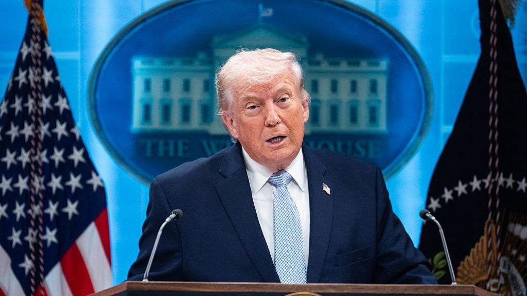 President Donald Trump conducting a news conference in the White House briefing room.