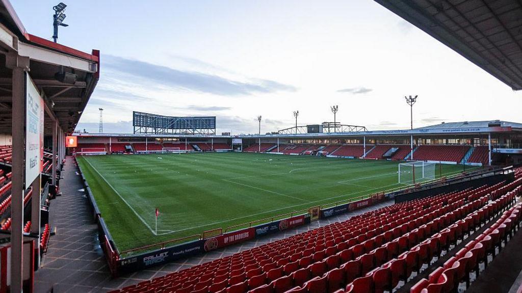 An empty Pallet-Track Bescot Stadium on a bright day, with light cloud in the sky