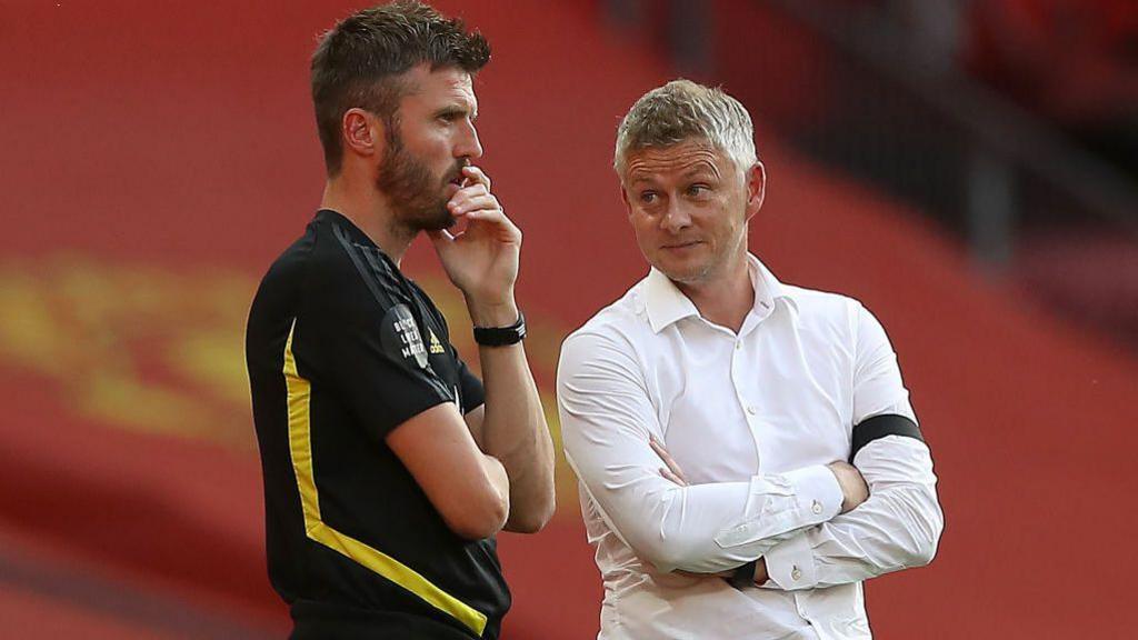 Ole Gunnar Solskjaer (R) talks with Michael Carrick on the touchline at Old Trafford