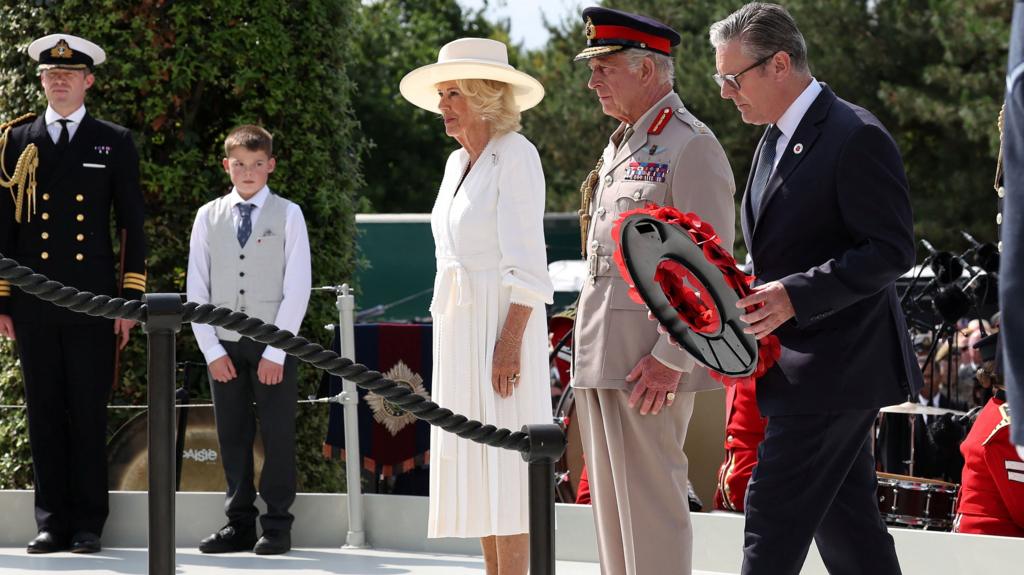 The King, Queen Camilla and PM Keir Starmer at the VJ Day service. Starmer is laying a wreath.